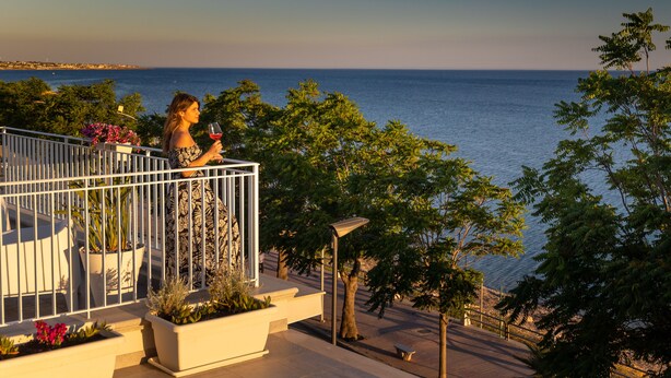 A balcony with a view of the sea, potted plants, and a railing. - Sunset Terrace Mazara - One bedroom flat with stunning  sea view rooftop (Mazara del Vallo)
