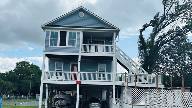 A two-story house with a covered porch and a garage.