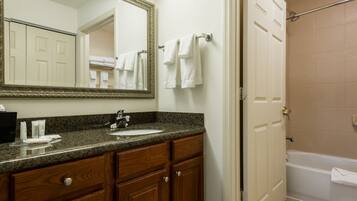 A bathroom with a sink, mirror, and towel rack.