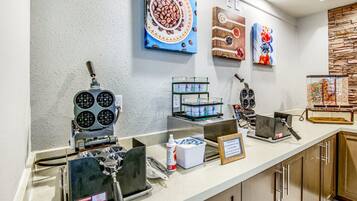 A breakfast bar with waffle makers, a coffee machine, and a variety of food containers.