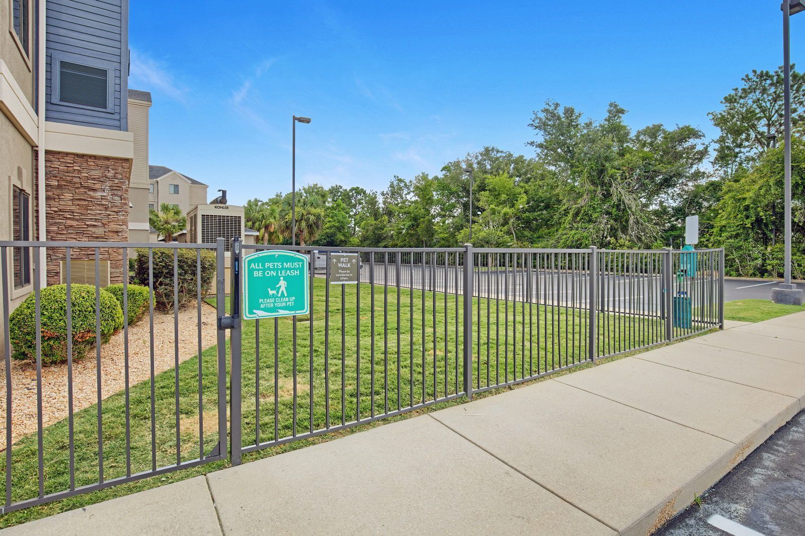 A fenced outdoor area with a sign indicating pet policy.