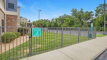 A fenced outdoor area with a sign indicating pet policy.