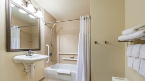 Un baño con lavamanos, espejo, ducha y bañera.