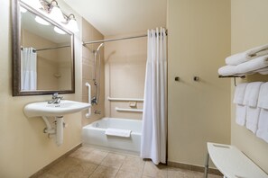 Un baño con lavamanos, espejo, ducha y bañera.