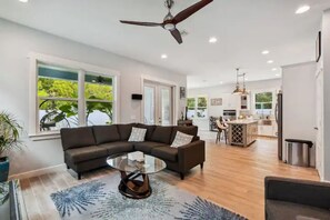 Relax in this spacious living area with a large sofa, coffee table, and kitchen bar.