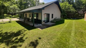 Yhden kerroksen rakennus, jossa on katettu kuisti ja pieni patioalue.