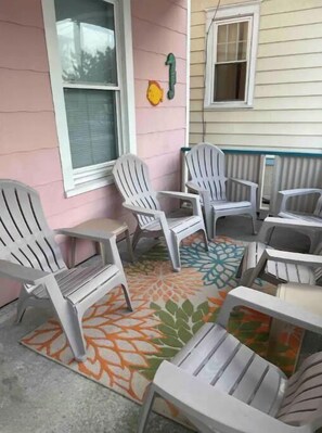 Relax in comfort on this inviting porch with Adirondack chairs and a cozy rug.