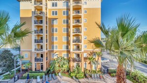 Un hôtel à plusieurs étages doté de balcons, d’une piscine et de palmiers.