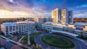 A modern building complex with multiple parking structures, a central courtyard, and a circular road layout. - Modern Studio - North Oak Park/UC Med Center (Sacramento)