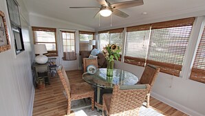 A dining area with wicker chairs, a glass table, and a ceiling fan. - 🐋Come enjoy paradise with us and bring the family🐾🌊 (Foley)