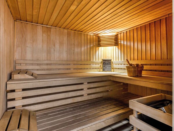 A wooden sauna with benches and a bench with a picture frame.
