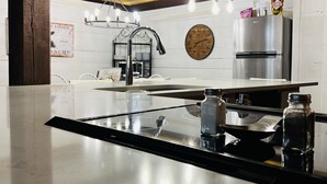 A modern kitchen with a central island, stainless steel appliances, and pendant lighting.