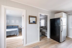 Eine moderne, gut beleuchtete Wohnung mit Küchenzeile, Essbereich und Wohnzimmer mit Sofa und Bett.