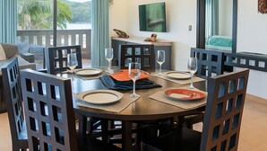 Zona pranzo con tavolo rotondo, sedie e ventilatore a soffitto.
