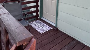 A small, single-story building with a door and a window, a wooden deck, and a welcome mat. - Bristol Short Stay for work, Nascar,Music, 1bdrm King size, Queen sleeper sofa.  (Bristol)