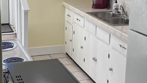 A kitchen with white cabinets, a black countertop, and a stainless steel sink. - Bristol Short Stay for work, Nascar,Music, 1bdrm King size, Queen sleeper sofa.  (Bristol)