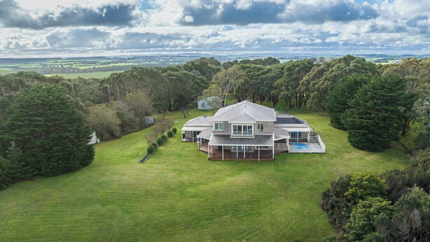 Une grande maison avec une vaste pelouse et une piscine.