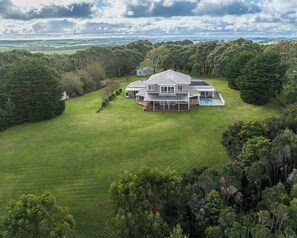Une grande maison avec une vaste pelouse et une piscine.
