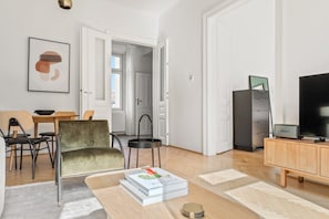 Relax in this stylish living room with a velvet armchair, coffee table, and bookshelf.