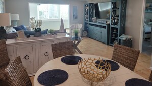 Un salon moderne comprenant un coin repas, un téléviseur et une cuisine.
