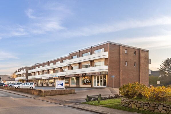 A multi-story hotel with a ground floor featuring a restaurant and a signboard. - Seestern - Bright app. for 2 pers. - Balcony, parking space, WLAN. Pets (Wenningstedt-Braderup (Sylt))