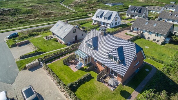 A residential area with houses, a paved road, and a grassy field. - Am Sandwall Ostseite - House close to the beach for 4 persons with sauna, terrace, garden, (Sylt)