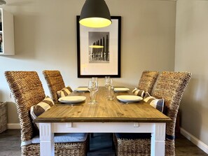 A dining table with six chairs, each with a woven seat cushion. - Apartment Pebbles - 3-room apartment for 4 persons with terrace, parking space, (Sylt)