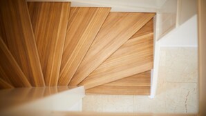 Eine moderne Treppe mit Holzwandverkleidung und Marmorboden.
