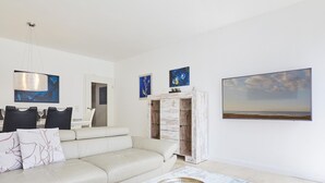 Ein modernes Wohnzimmer mit einer Couch, einem Couchtisch und einem Essbereich mit Stühlen und einem Tisch.