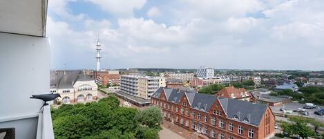 A cityscape with a prominent red brick building, a white tower, and a mix of residential and commercial structures.