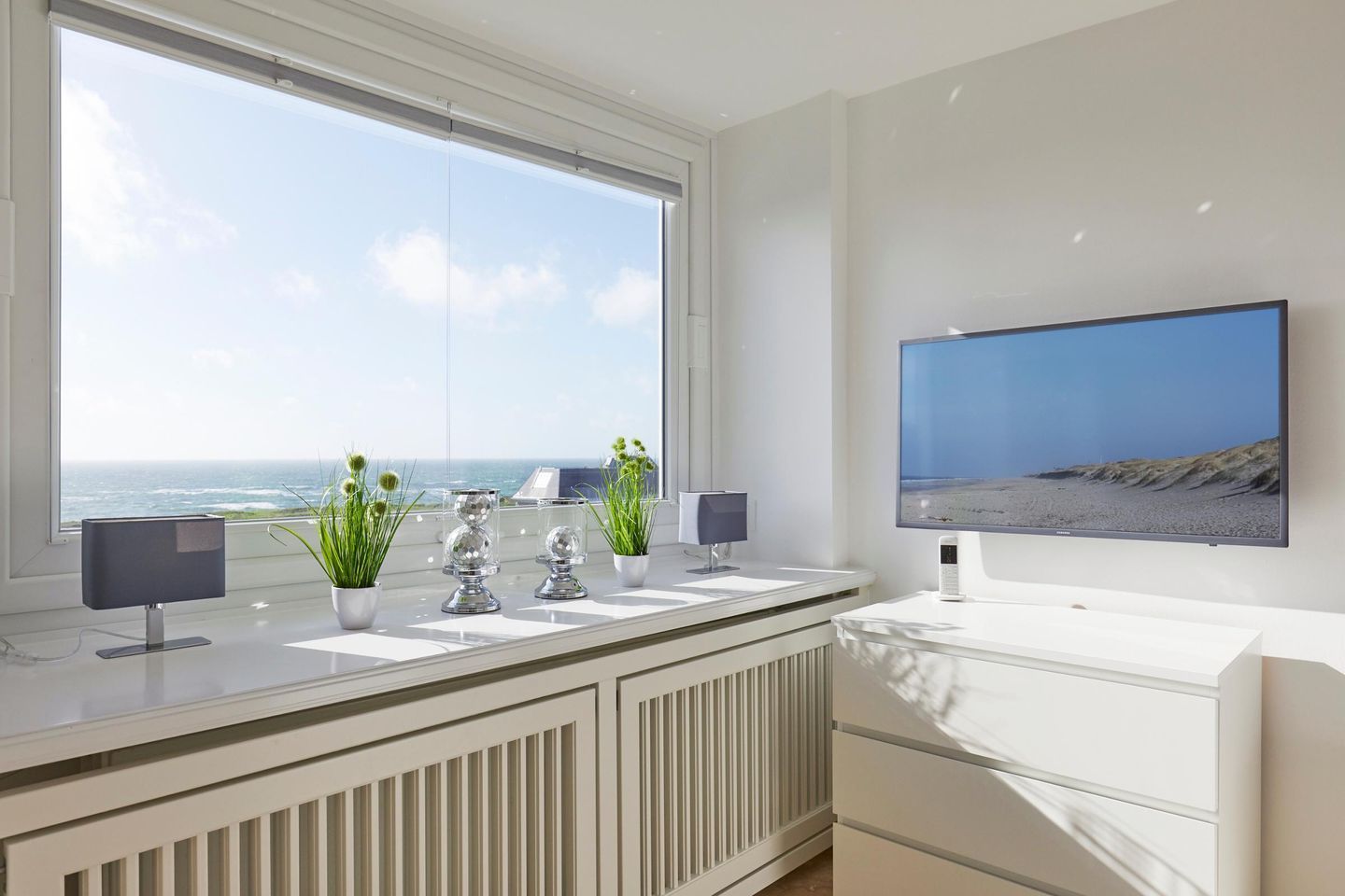 Une salle de bain moderne dotée d’une grande fenêtre, d’un téléviseur à écran plat et d’un radiateur.