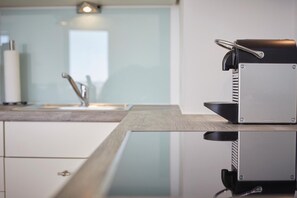 A modern kitchen with a sleek espresso machine on the counter. - Ocean View I - Modern apartment, balcony with ocean view, parking space, Wi-Fi. (Sylt)
