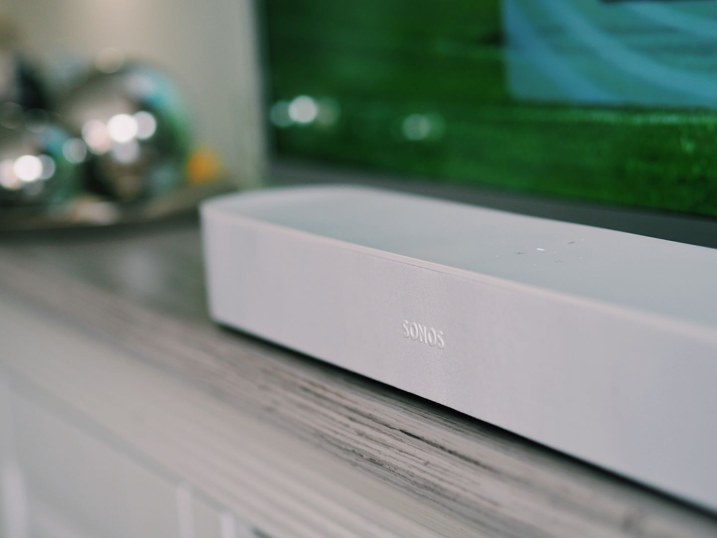 Un altavoz SONOS blanco sobre una superficie de madera.