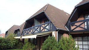A row of houses with pitched roofs and dark wooden beams. - Vacation apartment Warfstr. 5/3 - Wohnpark Werdum (Werdum)
