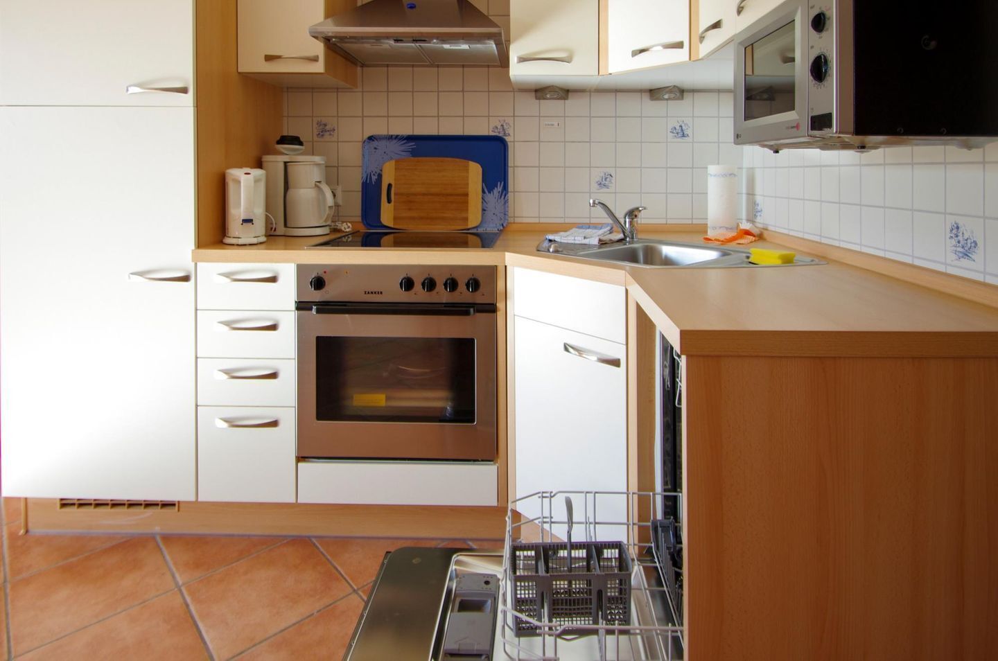 Una cucina moderna con forno integrato, macchina del caffè e microonde.