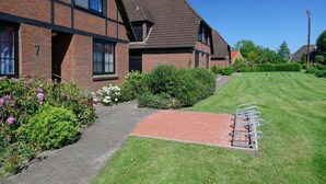 A residential building with a brick facade, a sloped roof, and a well-maintained lawn.