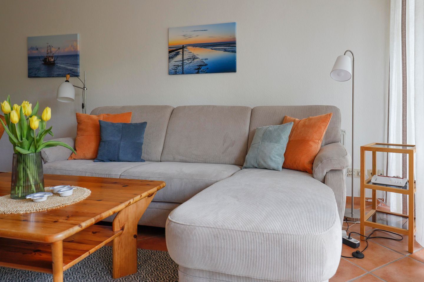 A living room with a sofa, a coffee table, a lamp, and a side table.