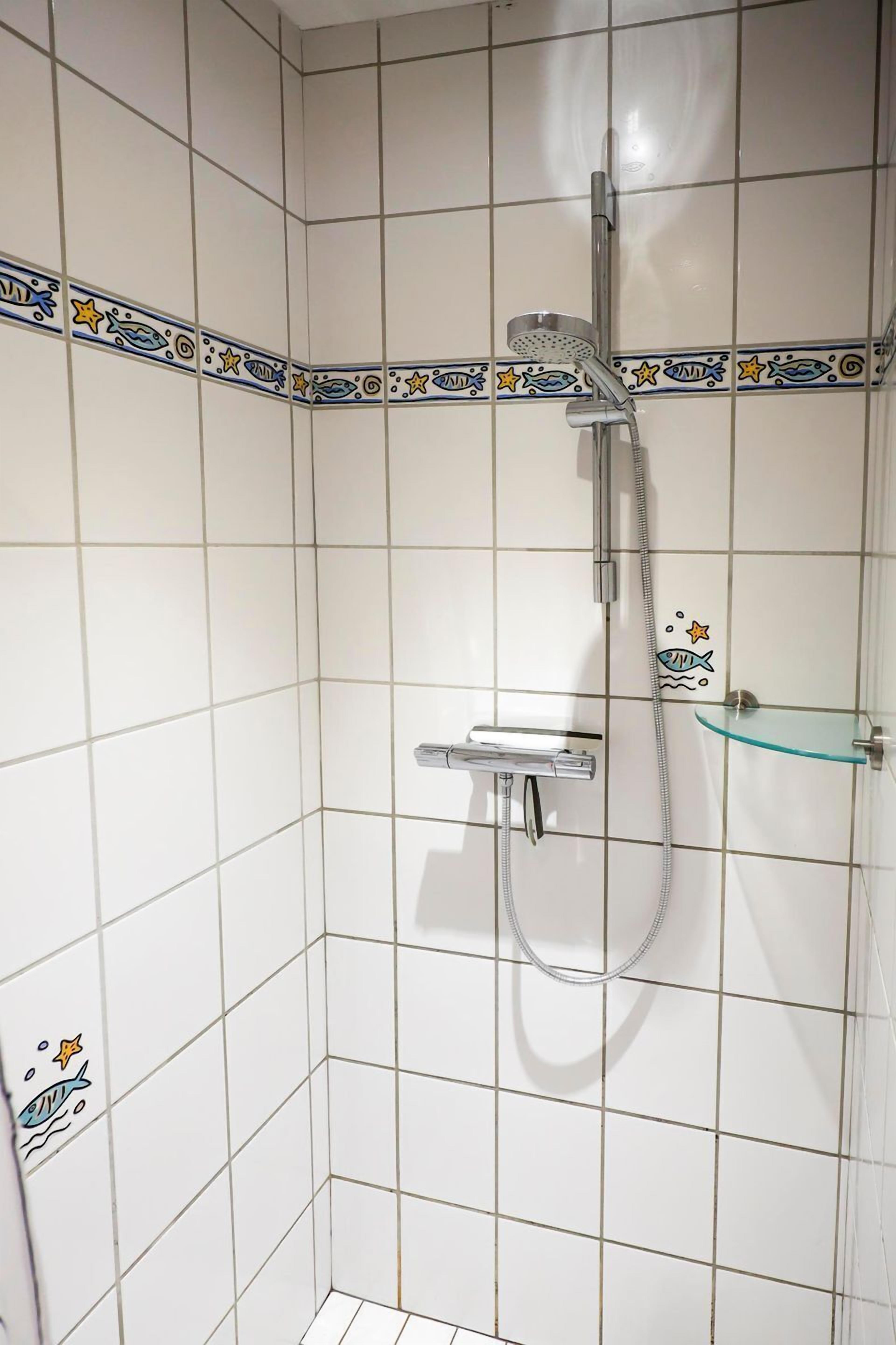 Ducha con cabezal de ducha de mano y grifo empotrado.