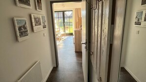 A hallway with a view to a dining area, white walls, and a radiator. - "Friesengeist" Werdum - Werdum residential park (Werdum)