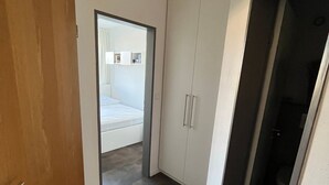 A hallway with a wooden door, a wardrobe, and a dark floor. - "Friesengeist" Werdum - Werdum residential park (Werdum)