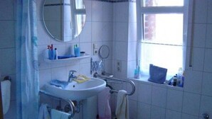 A bathroom with a sink, mirror, and window.