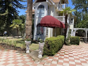 A house with a red umbrella, a white picket fence, and a well-maintained garden. - Historical Victorian Style House <br>Transport you back in time with Claw tubs  (Jamestown)
