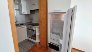 A compact kitchen with white cabinets, a stainless steel sink, and a built-in oven. - Imperiale front beach Apartment  (Viareggio)