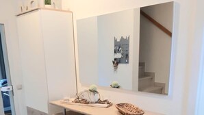 Une cuisine moderne avec un plan de travail en bois, un évier encastré et un grand miroir au-dessus du plan de travail.