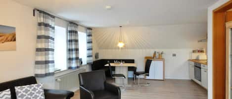 A compact living space with a dining area, kitchenette, and a seating area with a coffee table.