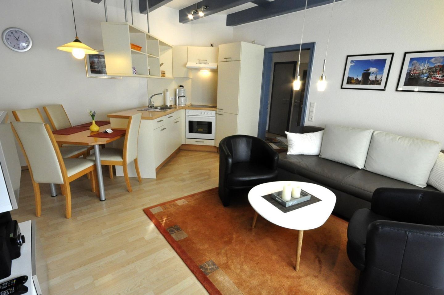 Een moderne woonkamer met een bank, een salontafel en een eetgedeelte met stoelen en een tafel.