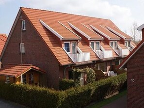 A row of townhouses with pitched roofs and dormer windows. - Vacation home Am Harlebogen 12 C (Wittmund)