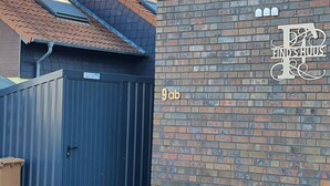 A brick wall with a large metal gate and a sign with the text 'FIND'SHUIS' and '9ab'. - Vacation home Krabbenpadd 9 "Find's Huus" - Holiday home "Find's Huus" Krabbenpadd 9 (Wittmund)