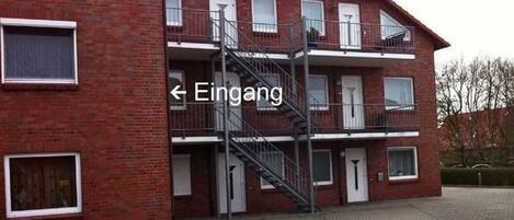 Ein rot backgebranntes Gebäude mit einer Treppe, die zu einem Balkon führt.