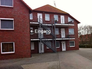 Een gebouw van rode baksteen met een trap naar een balkon.